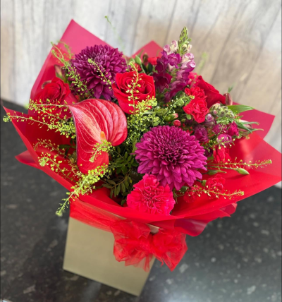 Ruby Passion - A bold and captivating floral arrangement featuring rich ruby red, deep berry, and vibrant cerise tones, beautifully complemented by fresh greenery and elegant textures. Expertly handcrafted to create a striking display of colour and sophistication, this bouquet is designed to make a lasting impression.

Presented in luxurious wrapping and a coordinating gift box, this eye-catching arrangement is perfect for romantic occasions, anniversaries, birthdays, celebrations, or any moment when you want to express heartfelt emotions in style.