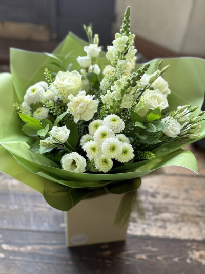 Serenity - A beautifully elegant bouquet featuring crisp white tones, fresh green accents, and lush seasonal foliage. Designed to evoke a sense of peace, purity, and natural beauty, this hand-crafted arrangement combines soft textures and graceful shapes to create a timeless and sophisticated display.

Presented in contemporary green wrapping and a coordinating gift box, this bouquet is perfect for expressing sympathy, celebrating new beginnings, sending congratulations, or simply brightening someone's day with a thoughtful gesture.