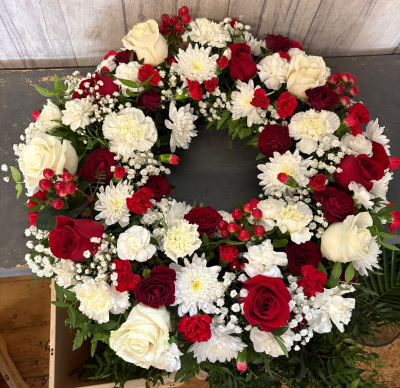 Wreath - A beautiful and heartfelt wreath designed to honour a life well lived and forever remembered. Featuring a classic combination of rich red and pure white tones, this elegant tribute symbolises love, respect, remembrance, and enduring affection.

Carefully handcrafted by a skilled florist, the circular design represents eternity and everlasting memories, making it a meaningful expression of sympathy and support. Suitable for funeral services, memorial ceremonies, or as a final farewell from family, friends, or colleagues.